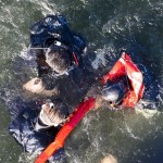 A Navy Search and Rescue (SAR) swimming instructor gives a pick-up signal to hoist up SAR students via rescue winch attached to a MH-60S Seahawk, assigned to the “Dragon Masters” Aviation Unit at Naval Surface Warfare Center Panama City Division, during a SAR training exercise Jan. 14, 2014. (U.S. Navy photo by Mass Communication Specialist Kevin B. Gray)
