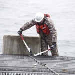 Burley Watkins, of Naval Surface Warfare Center Panama City Division (NSWC PCD) prepares to release concrete pilings and to create an artificial reef in the Gulf of Mexico waters off the coast of Panama City Beach, Fla., Jan. 30, 2014. Photo by Ron Newsome, NSWC PCD.