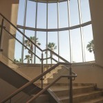 STAIRWELL WITH NEW CURVED GLASS WALL, CUSTOM TILE WORK AND GLASS/METAL RAILING